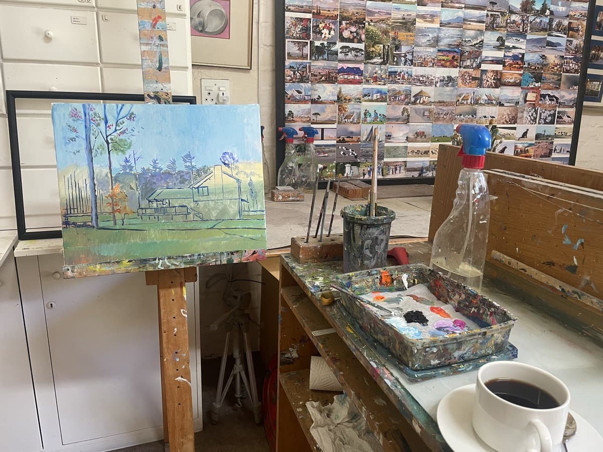 Painting in progress on easel in the artist studio with palette and brushes
